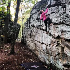 A person climbing up the side of a rock wall.