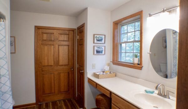 A bathroom with wood floors and white walls.