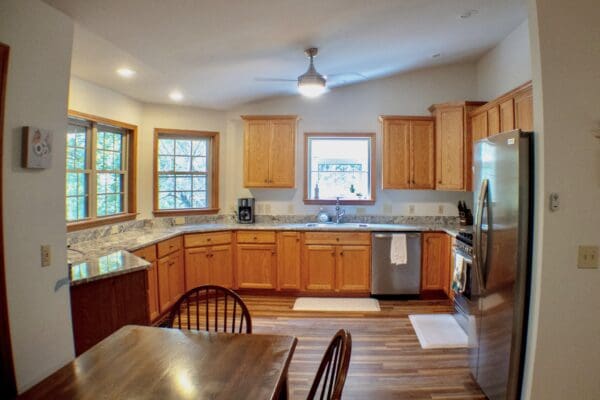 A kitchen with wooden cabinets and wood floors.